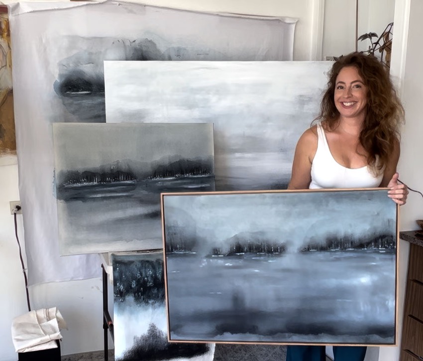 Michelle Jean in the studio with the landscape paintings